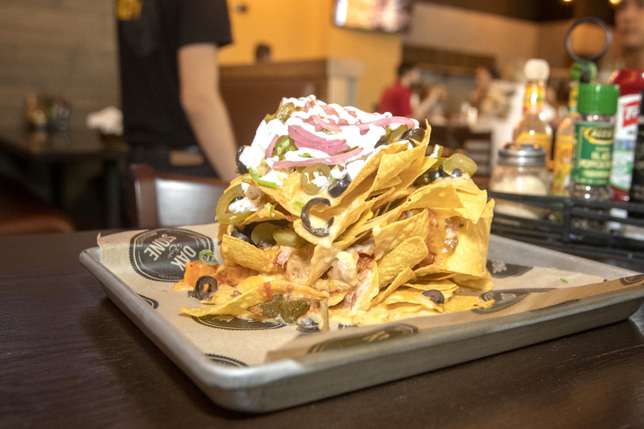 The chips are covered in firehouse chili, Cheddar sauce, black olives, jalape&ntilde;os, pickled red onion and lime sour cream.