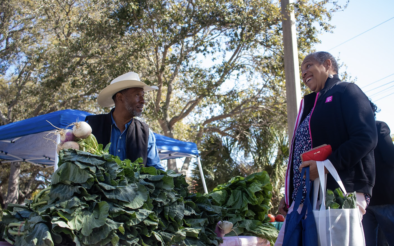 Ocala farmer Howard Gunn sells collard greens to a festival attendee.