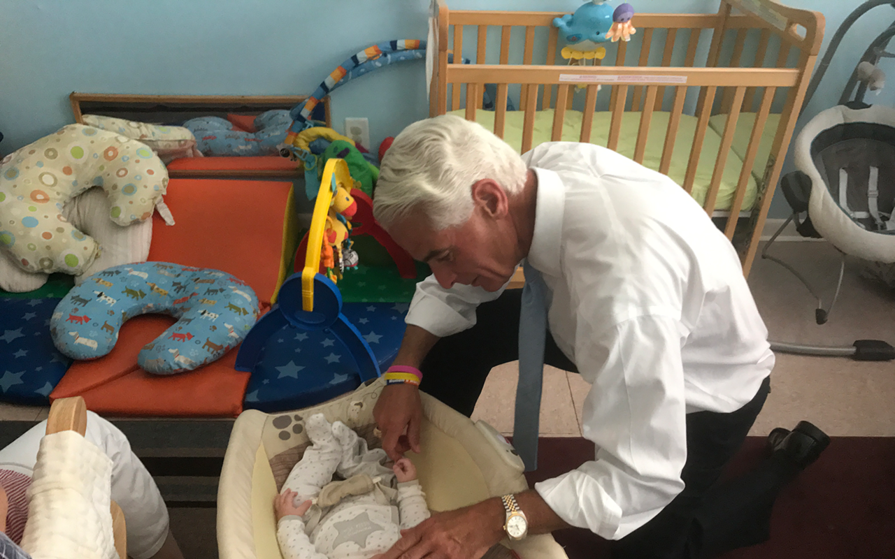 Rep. Crist with a baby at Operation Parental Awareness and Responsibility in Largo.