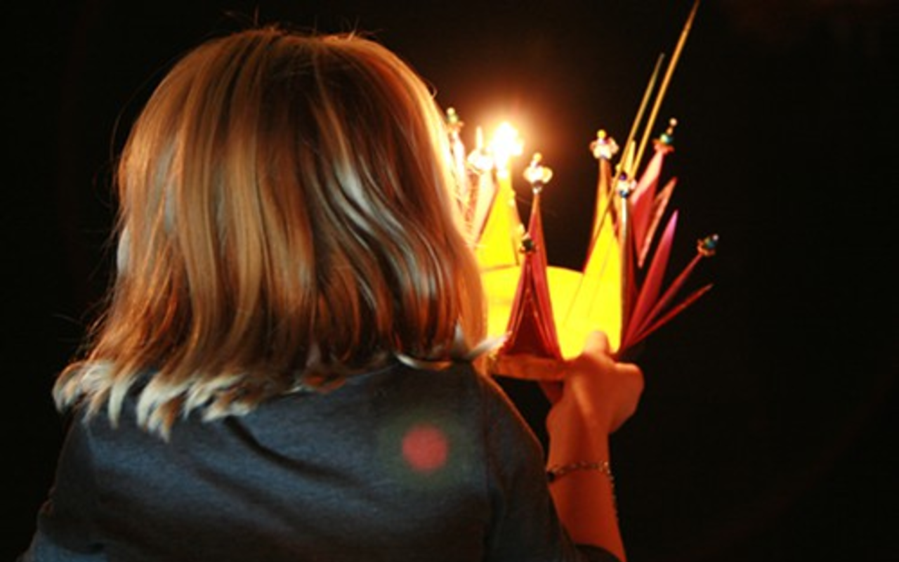 A small girl makes a wish before launching her krathong on the Palm River