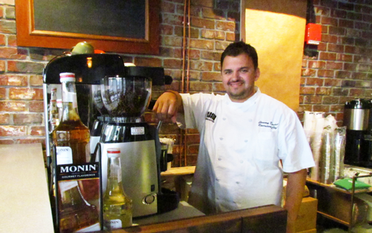 Co-owner Jeremy Duclut behind The Wooden Rooster’s coffee bar.
