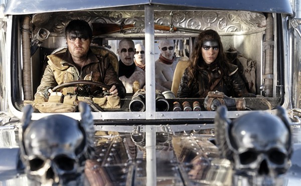 (From L to R) Praetorian Jack (Tom Burke) and Furiosa (Anya Taylor-Joy) drive into the melee with a gaggle of War Boys ready to die for the cause.