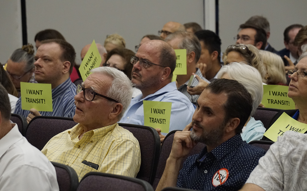 Critics of the revamped project held signs that read "I want transit."