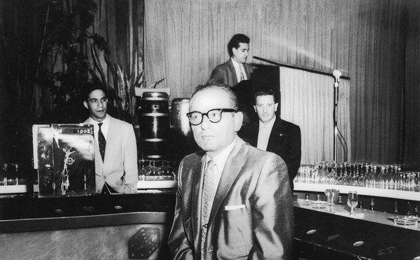 Santo Trafficante Jr. sitting on a stool in front of his bar at the Sans Souci Night Club in Havana, Cuba.