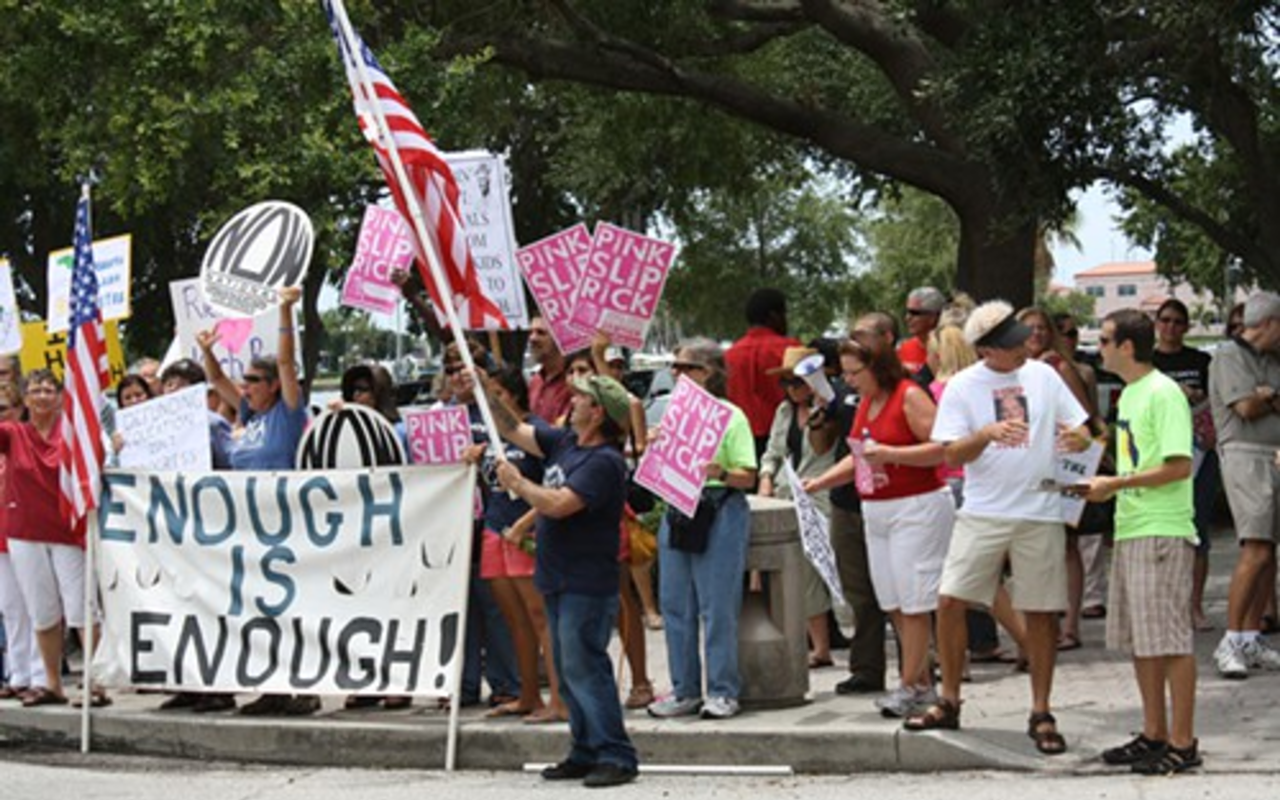 Protestors called for Gov. Rick Scott's pink slip in St. Petersburg on July 1.