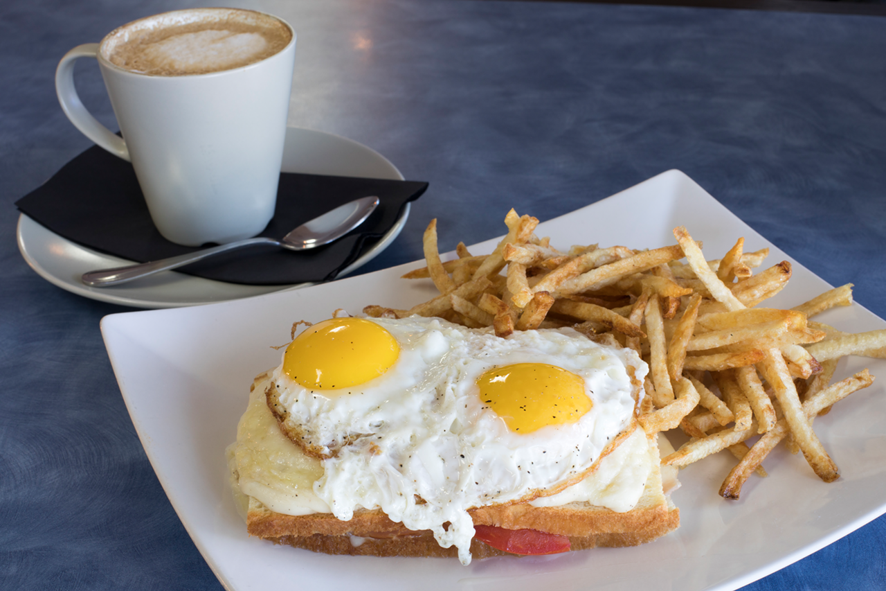 Served on brioche and topped with creamy sauce, the croque-madame features ham, Swiss, tomato, two eggs and a side of fries.