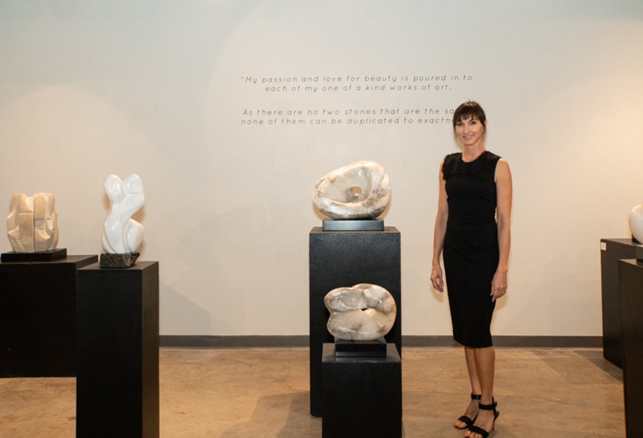 Christina Bertsos standing with her sculptures at ArtsXchange.