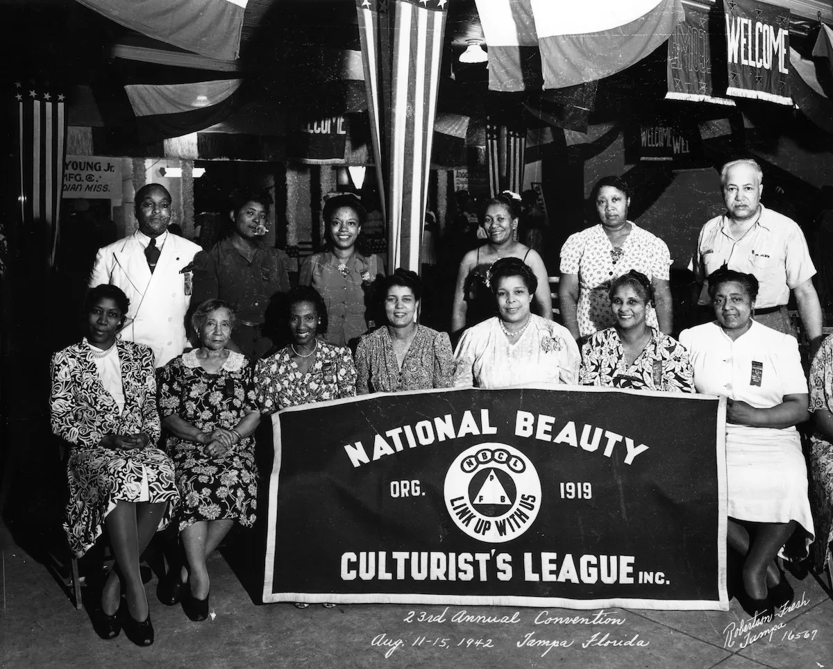 The National Beauty Culturist's League's 23rd annual convention at the Marti-Maceo Club on 1005 6th Avenue. The large group gathers in about five loose rows with the league's banner at the front to take a group portrait.