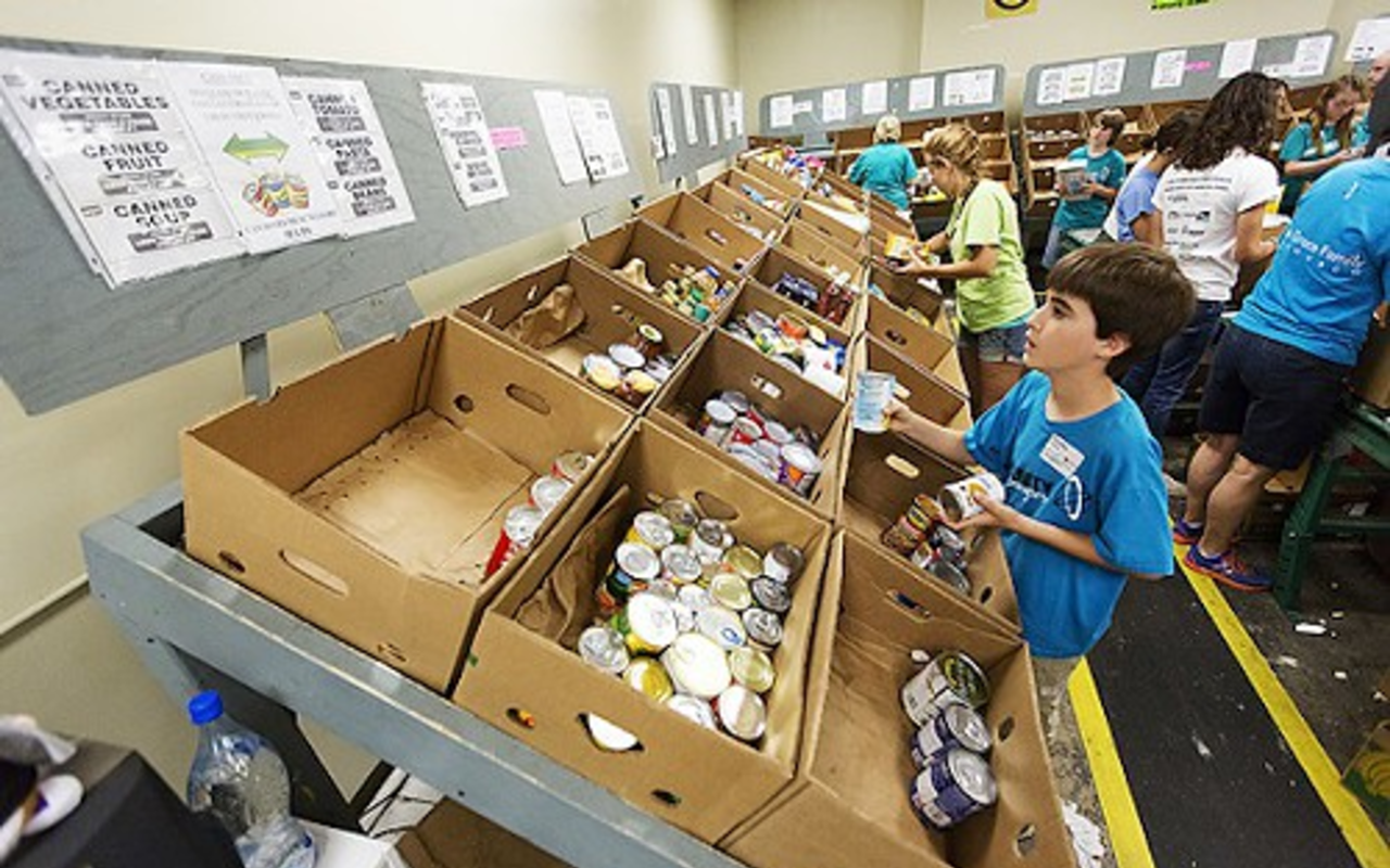 A volunteer sorts canned goods at Feeding America's Tampa warehouse