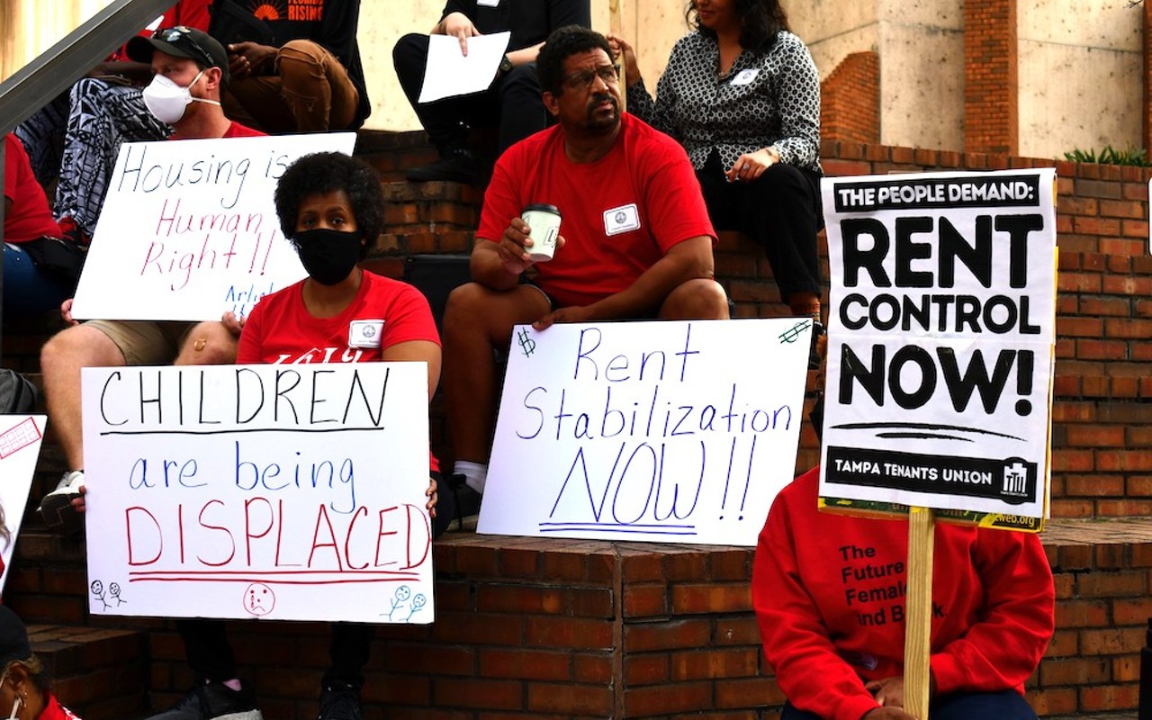 Renters at city hall hold signs demanding rent control.