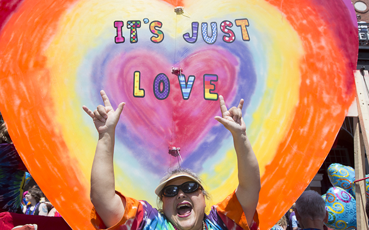 Dove Wimbish of the First United Church of Tampa  rides a float and spreads the word of love.