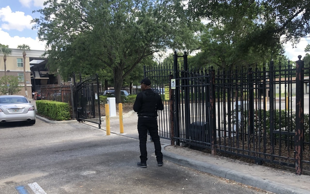 A security guard monitors the entrance and exit of Silver Oaks Apartments in East Tampa.