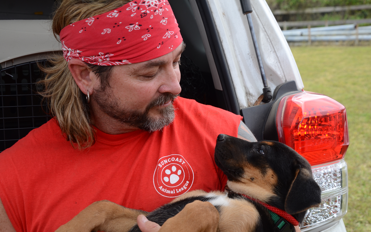 DOG’S BEST FRIEND: Suncoast Animal League volunteer Clint Wilson comforts a new rescue.
