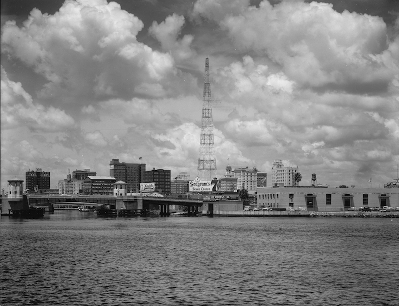 THEN
Downtown Tampa skyline and Platt Street Bridge 
View from Davis Islands, 1960.
Industrial buildings, warehouses, and port facilities once dominated the downtown Tampa waterfront. In the mid-1970s Mayor Bill Poe recognized the appeal of having public access to the waterways for residents and tourists and sought redevelopment. It took 35 years and over $35 million, but the Tampa Riverwalk that now fronts 2.6 miles along down the Hillsborough River from Water Works Park (opened in 2014) to the Channelside District, is now open.