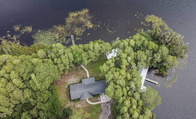 This Tampa Bay lake house comes with a cottage that sits over the water, and a peach orchard