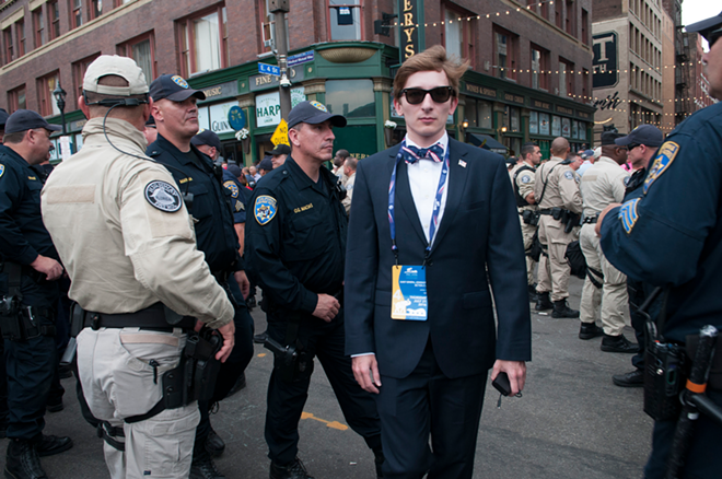 A young man walks past a phalanx of police towards the entrance of the Republican National Convention. - Joeff Davis