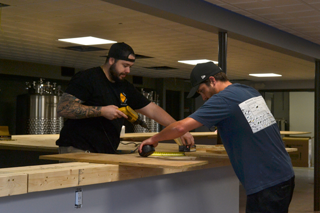 Lamb and Buckenham measure and affix plywood to the bar. After the bar top is complete, they'll cover its surface with metallic objects like gears and bolts. "There will be something to look at wherever you're sitting," Lamb says. - Ryan Ballogg