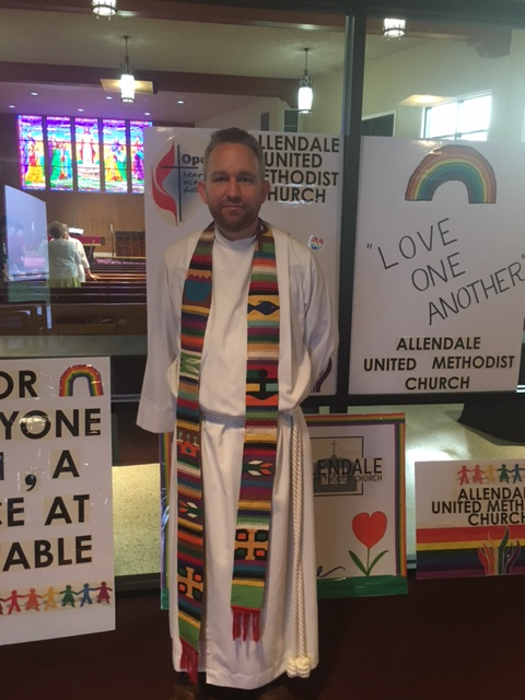 Rev. Andy Oliver posing with posters made for the Pride Parade - AMY KATSOURIS