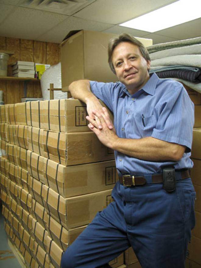 WHIPPED INTO ACTION: Rockin' Cards and Gifts owner Randy Heine stands by stacks of boxes containing whipped cream chargers in the back of his store. - Alex Pickett
