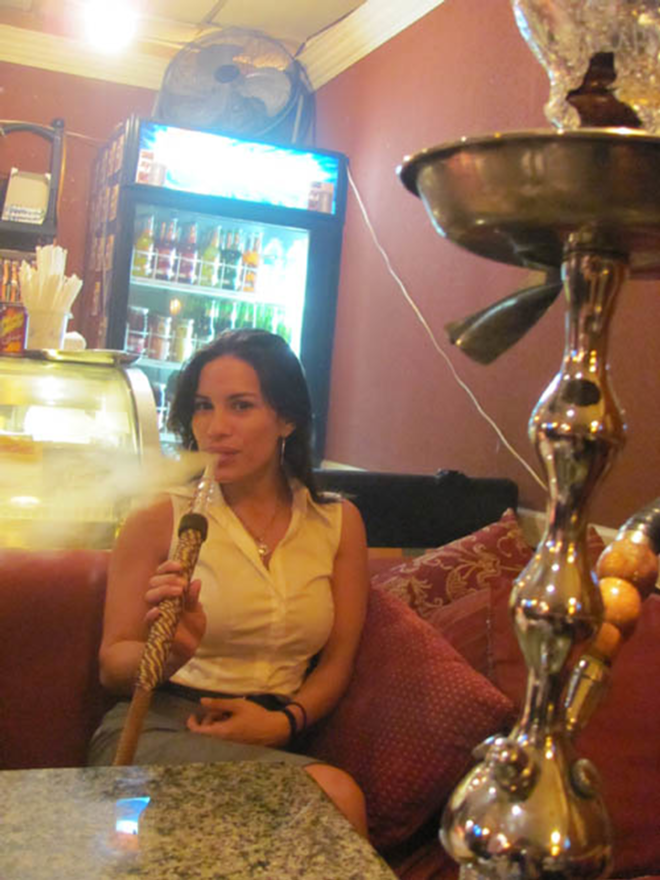 "ABOVE ALL, IT'S COOL": Carmen Valle smokes a pipe at the Babylon Hookah Lounge. - Mohamed Othman