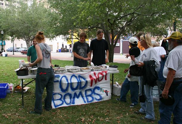 Food Not Bombs activists serves food to the needy despite the threat of arrest. - Anthony Martino