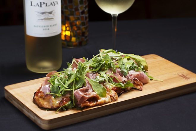 LIKE MAGIC: The grilled flatbread topped with prosciutto and arugula. - Chip Weiner