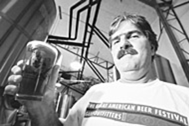 BREWING UP A GOOD TIME: Dunedin Brewery owner Michael - Bryant hoists a glass of his homemade beer. - Sean Deren
