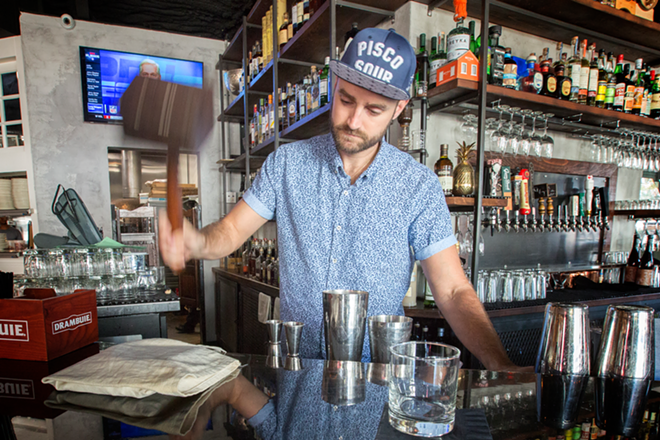 Behind the bar, Tony Finotti, who heads Proper's cocktail program, crushes ice the old fashioned way. - Chip Weiner