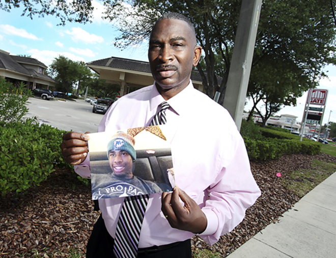 Ron Davis holds the last-known picture of his 17-year-old son Jordan Davis, who was shot and killed at this Jacksonville gas station Nov. 23, 2012. - Walter Coker/Florida Center for Investigative Reporting.