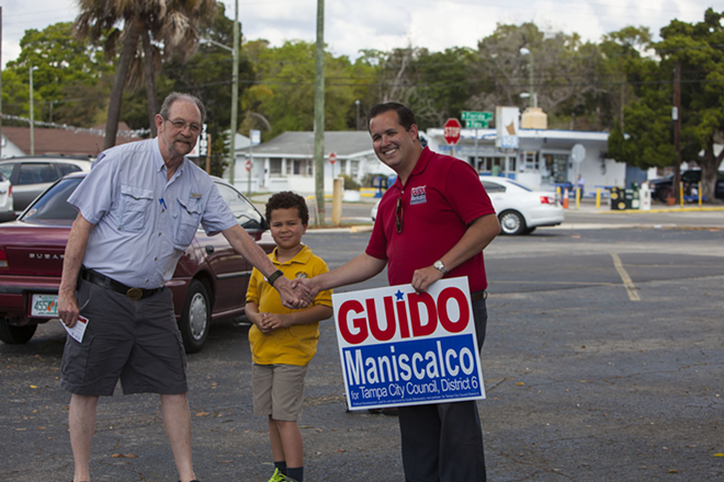Guido Maniscalco shakes hands with West Tampa resident Maurio Rendina. Grandson Miles Brady, 7, in the center. - Kimberly DeFalco