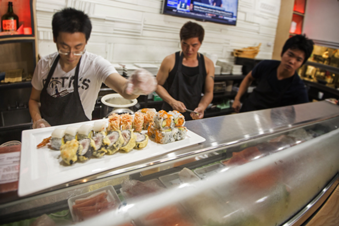 The restaurant's staff prepares offerings at the stylish sushi bar. - Chip Weiner