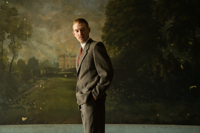 Dr. Faraday (Domhnall Gleeson) stands in front of a mural of Hundreds Hall, the possibly haunted mansion at the heart of The Little Stranger. - Focus Features