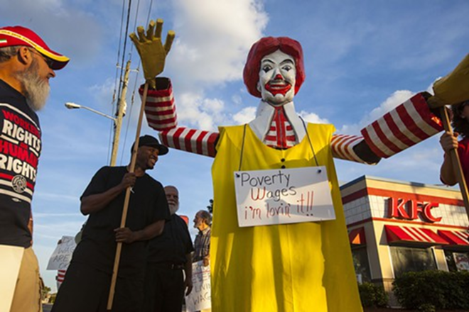 Protesters lead a Ronald McDonald effigy in protest of minimum wage and working conditions. - Kimberly DeFalco