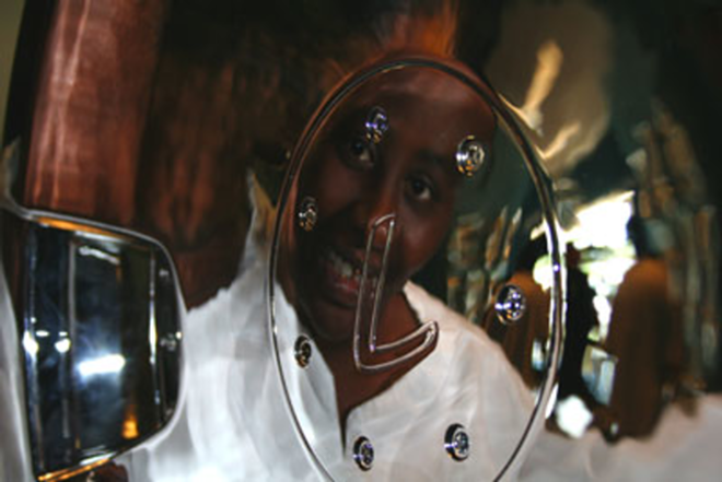 "SOMETHING FOR ME": Toquanda Baker smiles at her reflection in the shiny new 20s on her '93 Infiniti. - Wayne Garcia