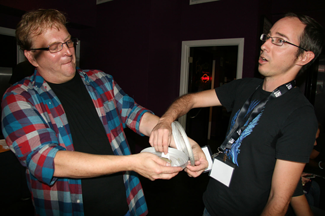 Sunshine Syndicate team member John C. Jones, right, reaches for his genre as 48 Hour Film Project Producer Joel Bates holds the choices. - Kimberly DeFalco