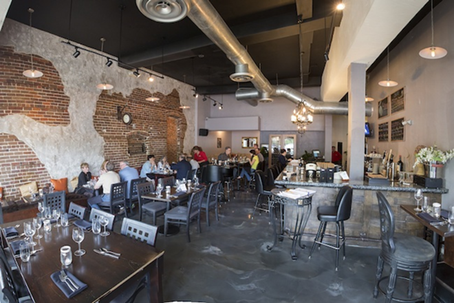 An exposed brick wall and huge HVAC pipes complete the restaurant's inviting industrial-chic vibe. - CHIP WEINER