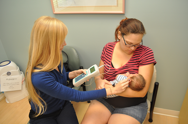 NOW HEAR THIS: Nurse and lactation consultant Ashley Homan performs a hearing test on Sarah Davidson’s newborn at a postpartum appointment at Breath of Life. - HEIDI KURPIELA