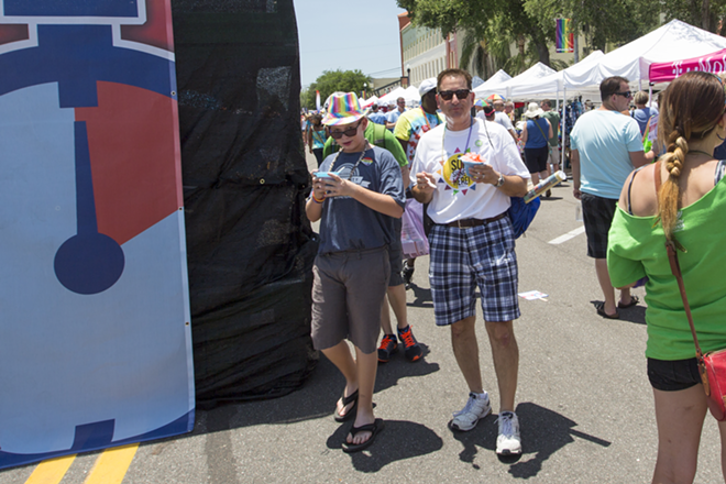 St. Pete Mayor Rick Kriseman and his son Samuel stroll through the festival with shaved ice to stay cool. - Chip Weiner