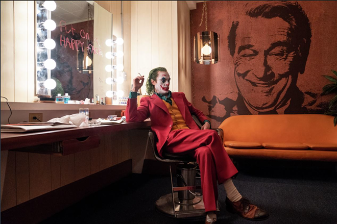 Arthur Fleck (Joaquin Phoenix), in full regalia, enjoys a quiet moment before setting the world on fire in the brilliant "Joker." - Niko Tavernise/Warner Bros. Entertainment