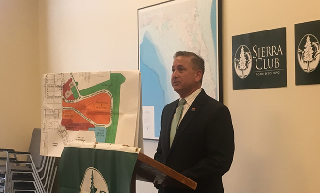 Mayor Rick Kriseman stands next to a map of what he said his opponent, former mayor Rick Baker, supported as a replacement for Albert Whitted airport and a nearby sewage treatment plant. The plant closed under Kriseman in 2015, but talk of closing it first occurred under Baker. - Kate Bradshaw