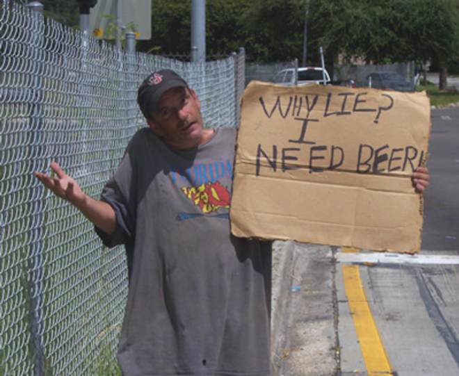 AT LEAST HE'S HONEST: A Tampa homeless man holds his sign on a Sligh Avenue off-ramp. - Dawn Morgan