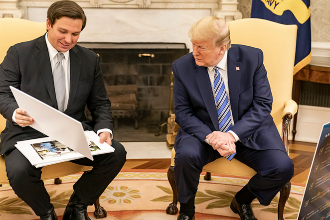 President Donald J. Trump looks at diagrams and photos during his meeting with Florida Gov. Ron DeSantis Tuesday, April 28, 2020, in the Oval Office of the White House. - Official Photo by Shealah Craighead