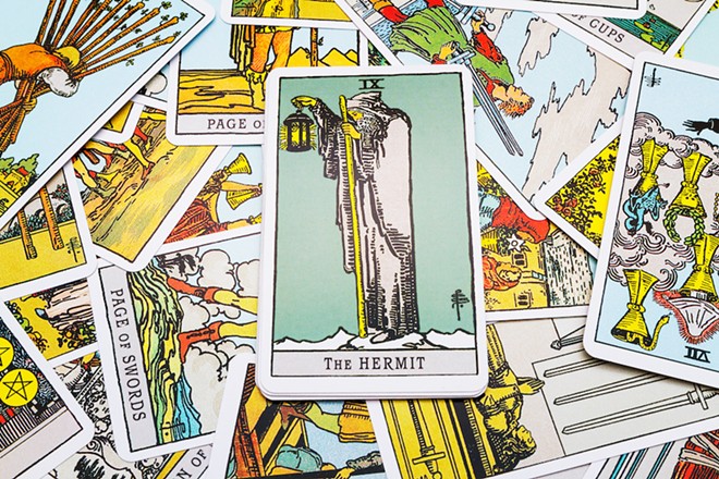 The Hermit reversed is the card guiding this spread, holding a lamp into the dark. - VOLKOVSLAVA/ADOBE