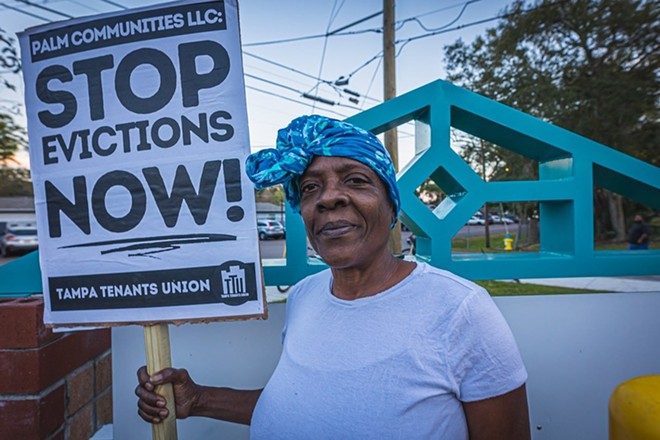 A tenant at Holly Court holds a sign during a protest. - Dave Decker