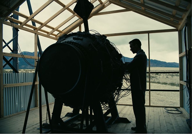 J. Robert Oppenheimer (Cillian Murphy) stands next to his creation, the atomic bomb. Nuclear annihilation. Which should scare us a lot more than equal opportunity. - Photo via Universal Pictures