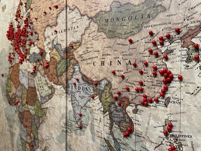 At the James Museum's ‘From Far East to Far West,' a bulletin board invite guests to visualize their ancestry by pushing red pins onto a world map. - Photo by Jennifer Ring
