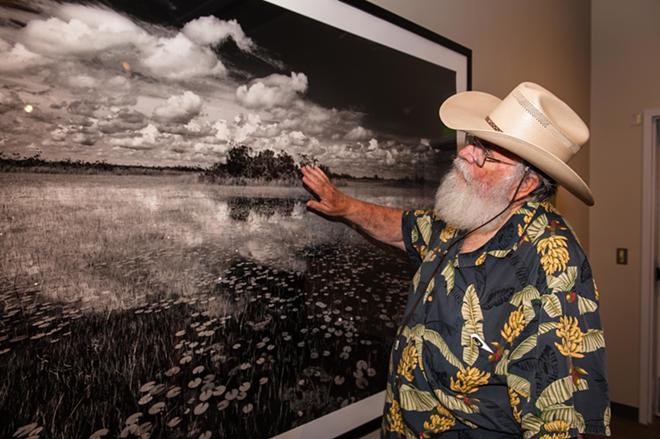 Clyde Butcher points to a telling detail in his photograph, "Ochopee," at the Tampa Bay History Center. - Nick Cardello
