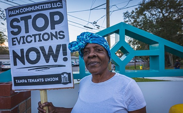 A tenant at Holly Court holds a sign during a protest.