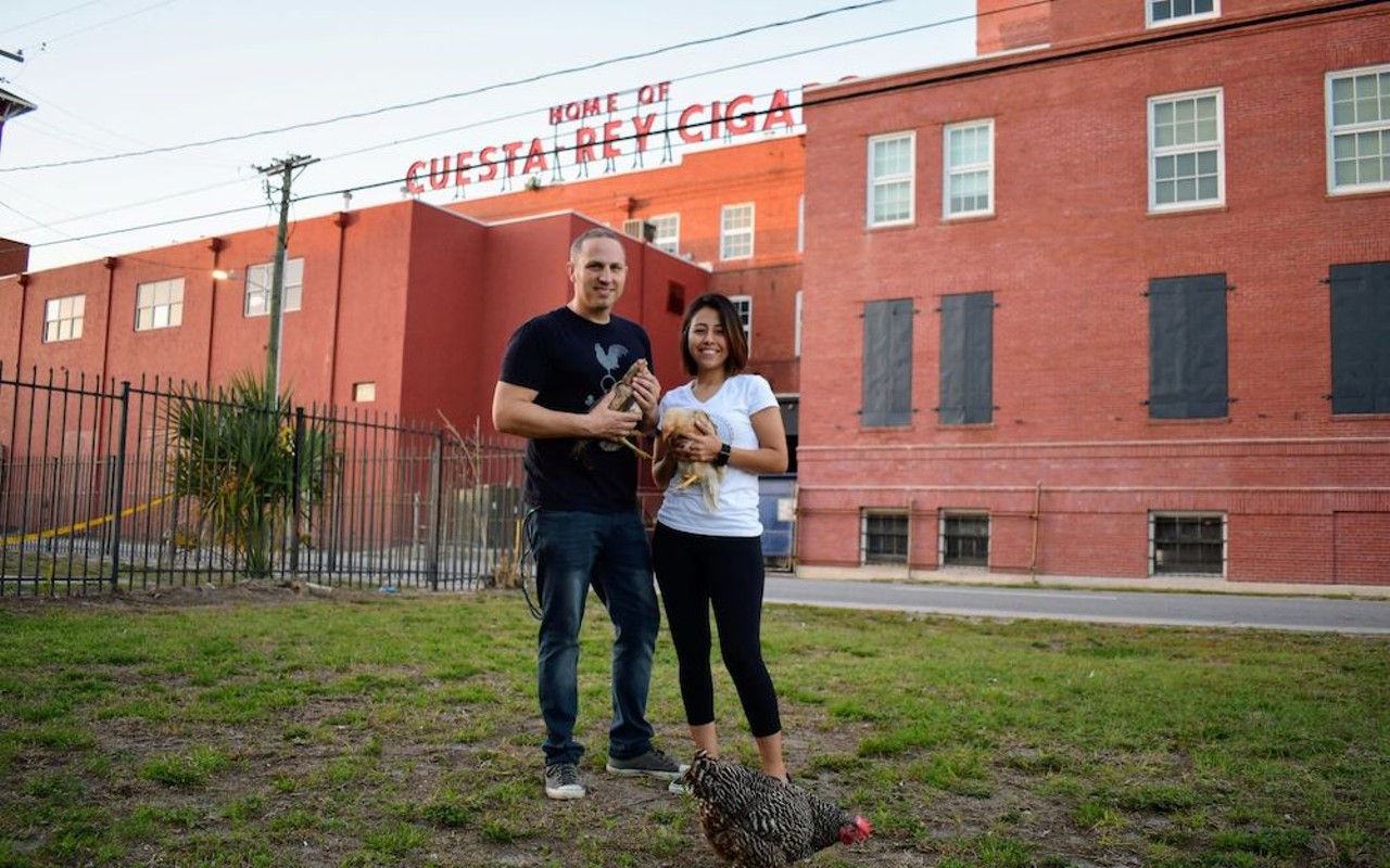 Dylan Breese (L) and Anahy Gutierrez with a few chicken rescues in front of the JC Newman Cigar Company.