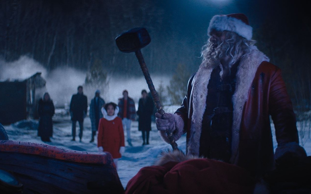 Santa Claus (David Harbour, right) prepares to hammer some bad guy ass as Trudy (Leah Brady) and her family look on in awe